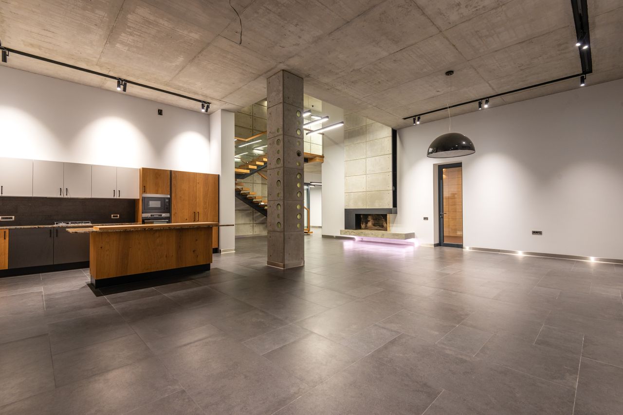 Interior design of modern minimalist style cottage house with open plan kitchen and spacious hallway with stone pillar and LED illumination
